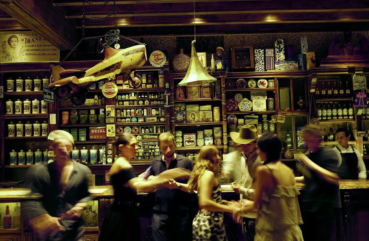 Friends dancing and gathered around a bar mid-motion